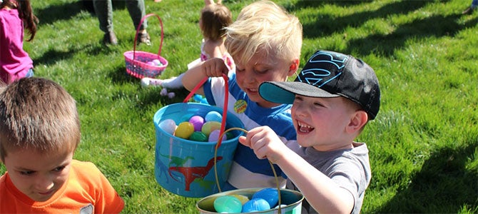 A group of kids show off their buckets full of Easter eggs they collected from the Nu Skin Easter Egg Hunt.